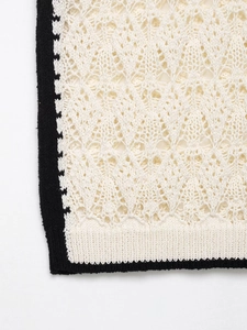 Détail macro du tricot au crochet beige avec motifs géométriques et bord noir