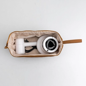Interior view of brown leather organizer bag holding a white hair dryer for storage