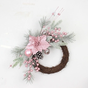 Pink Christmas wreath with flocked pine needles, berries, and ornaments on a vine base