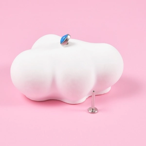 Silver stainless steel labret stud featuring a heart-shaped blue opal on a cloud ceramic stand