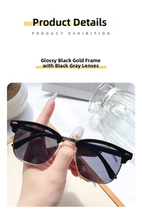 Detail of semi-rimless sunglasses in glossy black and gold frame with dark grey lenses