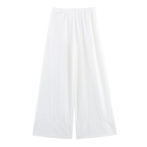Detailed flat lay of white linen wide-leg pants featuring delicate hollow lace hem