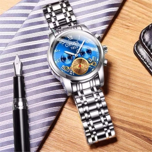 Detail of blue dial business watch with steel band and dual calendar display on desk