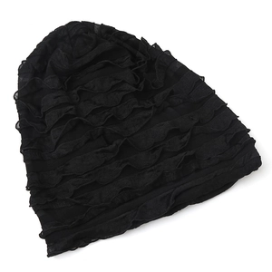 Detail view of the black pleated slouchy beanie showing tiered ruffle fabric texture