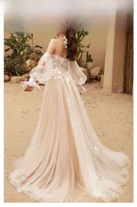 Detail of off-shoulder lace wedding dress with champagne tulle and floral embroidery