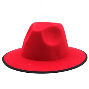 Détail du chapeau fedora en feutre rouge avec bordure noire et calotte pincée classique