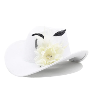 Detail of white felt cowboy hat featuring elegant feathers and cream floral accent