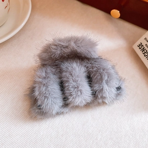 Close-up of grey plush faux fur hair claw clip with a soft winter aesthetic design