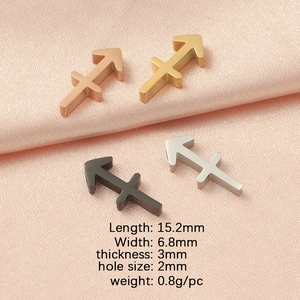 Detailed view of arrow pendants in rose gold, gold, black, and silver on pink satin fabric
