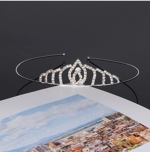 Detailed close-up of a silver bridal crown with sparkling rhinestones on a dark surface