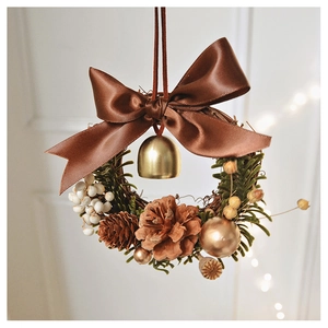 Mini Christmas wreath detail with brown silk bow, golden bell and natural pinecones