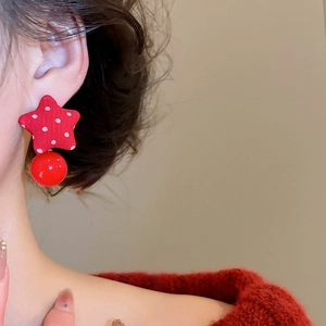Close-up of red star fabric earrings with white polka dots and hanging red drop bead