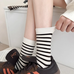 Detail showing elastic ribbing and black and white stripes of the mid-calf cotton socks