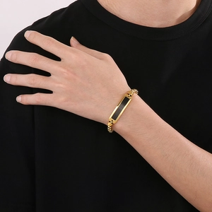 Close-up of men's gold hip hop bracelet with a black rectangular plate on wrist