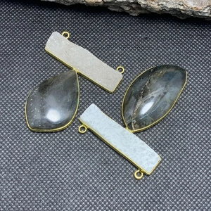 Vista dettagliata dei ciondoli in labradorite e agata con bordi placcati oro 14 carati