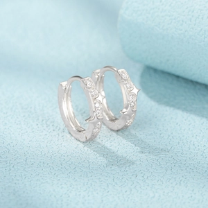 Macro shot of silver S925 sterling silver hoop earrings with stars and zircon stones
