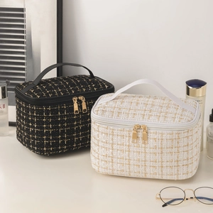 Quilted tweed makeup bag with gold zipper and handle in black and cream white