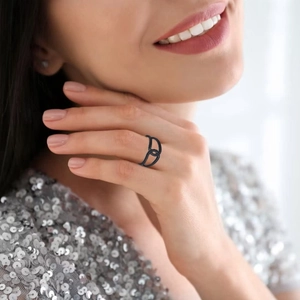 Detail view of black interlocking chain link ring worn by model in elegant silver setting