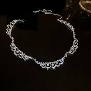 Macro view of silver lace-patterned necklace with sparkling diamond-set geometric crystals