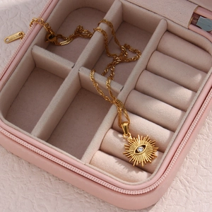 Golden Evil Eye radiant pendant necklace with K18 stamp shown in a pink jewelry box