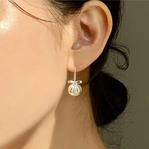 Elegant 925 sterling silver bow knot earrings with white pearl drop shown on model