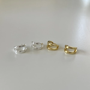 Close-up of double-layer C-shaped hoop earrings in polished gold and silver finishes