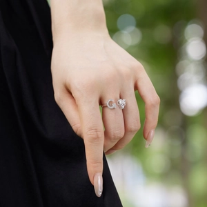 Macro detail of silver adjustable ring with G letter and heart shape on a model