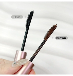 Close-up of mascara brushes in black and brown colors with pink metallic tubes