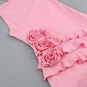 Detailed close-up of handmade 3D rose flower and layered ruffles on pink dress fabric