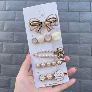 5-piece hair clip set featuring pearls, resin bears, and floral designs on display card