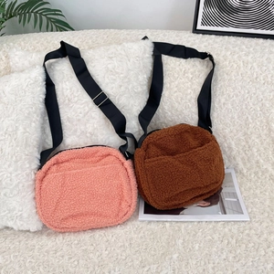 Close-up of plush lamb wool round crossbody bags with adjustable nylon shoulder straps