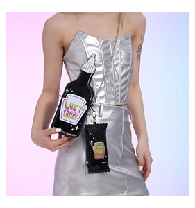 Close-up of black patent leather sauce bottle shaped crossbody bag with metal chain