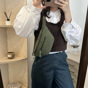 Green corduroy cross-body waist bag with triangular zipper pulls in minimalist style