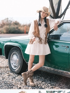 Retro western straw hat paired with a white dress and vintage green car in outdoor setting