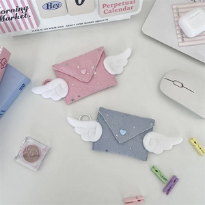 Detailed flatlay of cute envelope pouches with plush wings and star patterns