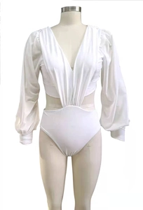 Detail of white one-piece swimsuit with deep V-neck, ruched front and puff sleeves