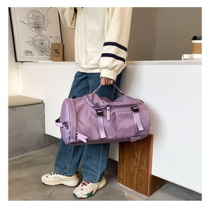 Detailed shot of purple waterproof nylon gym bag held by model in modern studio setting