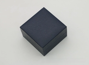 Macro detail of dark blue textured faux leather surface on a square watch storage box