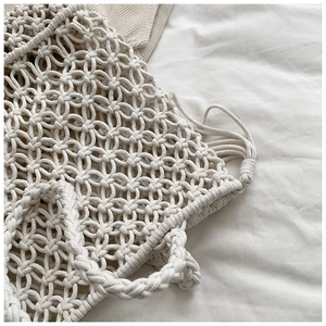 Macro detail of creamy white cotton rope knots and intricate macramé texture on the bag