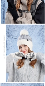 Detail of white knit beanie with faux fur pom pom and matching touchscreen gloves for winter