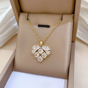 Detail of a gold heart pendant necklace with square-cut zircons in a jewelry box