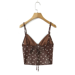 Detailed view of brown polka dot camisole with lace trim and ribbon bow on wood hanger