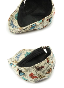 Detailed view of butterfly jacquard fabric and adjustable bronze buckle on retro cap