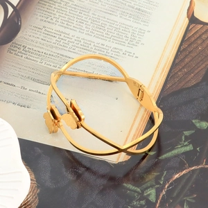 Detailed close-up of a double-layer butterfly cuff bracelet on a vintage book