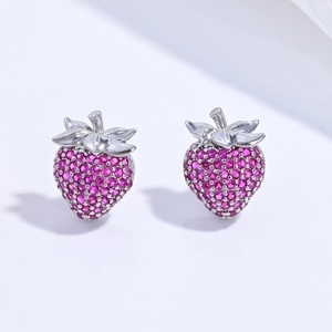 Macro shot of silver strawberry stud earrings featuring pavé-set rose red crystals