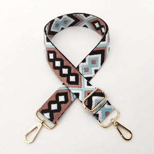 Detail of colorful geometric woven bag strap with golden metal lobster clasps and buckle