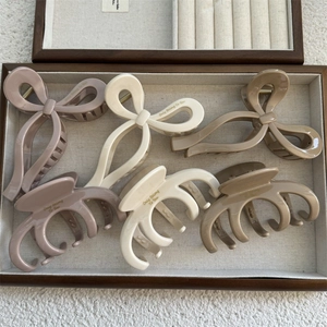 Bow hair claws in Morandi colors displayed in a wooden jewelry case for thick hair