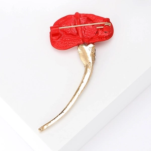 Elegant red fabric ginkgo leaf brooch with gold stem and rhinestones on white display