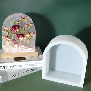 Detail of arch resin mold with a dried rose floral art piece on a wooden base