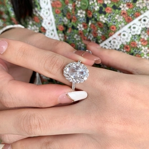 Close-up of S925 sterling silver ring with oval halo cubic zirconia on model finger
